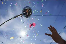  ?? GERALD HERBERT — THE ASSOCIATED PRESS FILE ?? A Societe de Sainte Anne parade-goer reaches for confetti during Mardi Gras on Tuesday in New Orleans.