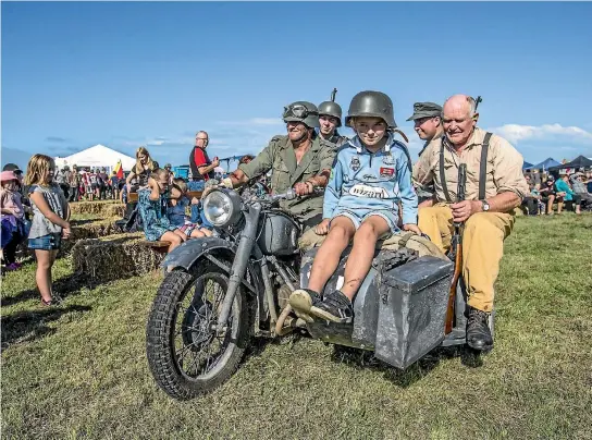  ?? PHOTO: DOUG FIELD/STUFF ?? On a German sidecar motorcycle are Glen Hewison, left, Mitchell Soper, Tommi Hewison, 9, Antony Smith, and Rod Harvey at the Anzac in Action display at Rangitata Island on Saturday.