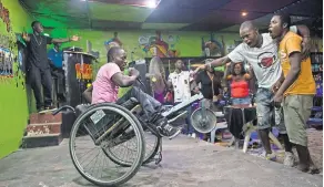  ?? JIM TUTTLE FOR THE NEW YORK TIMES ?? Emmanuel Dongo had polio as a child, leaving his legs withered. He performs as Lyrical D at a club in Monrovia.