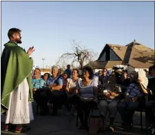  ?? AP PHOTO/DAVID GOLDMAN ?? Father Michael Nixon holds Mass outside Saint Dominic Catholic Church which stands damaged in the background form hurricane Michael in Panama City, Fla., on Saturday.