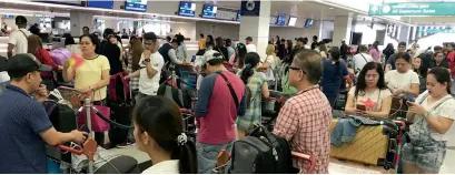  ?? Photos by Angel Tesorero ?? The second batch of 117 Filipinos wait for their turns at Dubai Internatio­nal Airport to fly back to their home country on Saturday. —