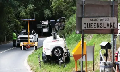  ?? Photograph: Jason O’Brien/AAP ?? A car is stopped for checking at Tomewin, on the Queensland-New South Wales border, after Queensland’s border restrictio­ns came into force from midnight on Wednesday to slow the spread of Covid-19.