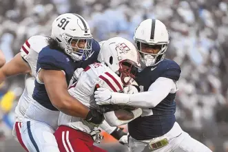  ?? BARRY REEGER / ASSOCIATED PRESS ?? Penn State defenders Dvon Ellies (91) and Abdul Carter tackle UMass running back Kay’Ron Lynch-Adams during the first half of their game last weekend in State College, Pa.