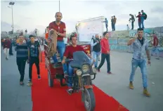  ?? — AFP ?? Palestinia­ns drive their motorcycle on the red carpet during a film festival showcasing films focusing on human rights, in Gaza City on Friday.