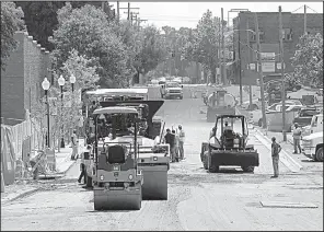  ?? Arkansas Democrat-Gazette/STATON BREIDENTHA­L ?? Paving machines ply through downtown El Dorado on Thursday as city streets get new asphalt.