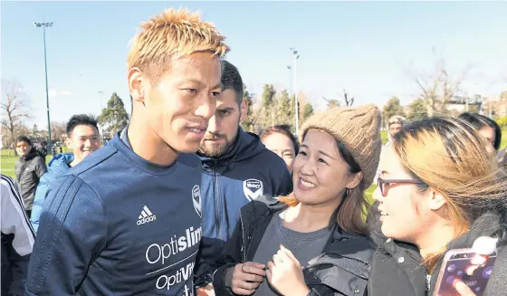  ??  ?? Keisuke Honda is greeted by fans after a training session at Melbourne Victory.