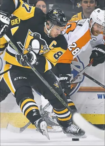  ?? Peter Diana/Post-Gazette photos ?? Sidney Crosby battles for the puck with the Flyers’ Claude Giroux, right, during the Penguins’ 5-4 win Sunday at PPG Paints Arena.