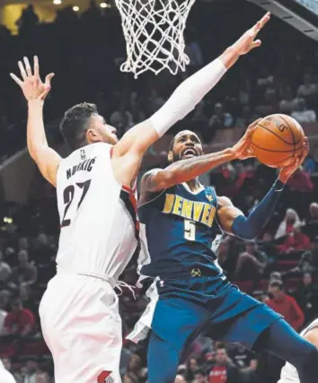  ?? Steve Dykes, The Associated Press ?? Nuggets guard Will Barton drives to the basket on Portland Trail Blazers center and former Denver teammate Jusuf Nurkic during the first half of Monday night’s game.
