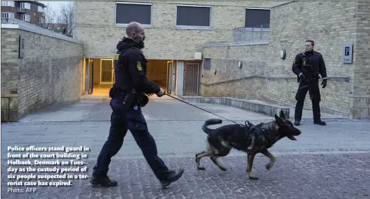  ?? Photo: AFP ?? Police officers stand guard in front of the court building in Holbaek, Denmark on Tuesday as the custody period of six people suspected in a terrorist case has expired.