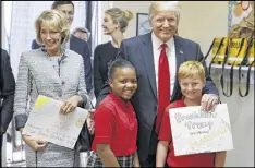  ?? ALEX BRANDON / AP ?? President Donald Trump and Education Secretary Betsy DeVos with Janayah Chatelier, 10, (left) and Landon Fritz, 10, at Saint Andrew Catholic School.