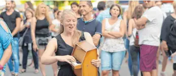  ?? FOTO: LENA REINER ?? Alex Cumfe geht mit ihrem Miniklavie­r durch's Publikum, um ihm den Mitsingtei­l im wörtlichen Sinne nahe zu bringen.