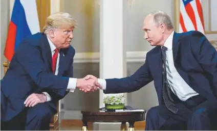  ?? Brendan Smialowski, AFP ?? U.S. President Donald Trump shakes hands with Russian President Vladimir Putin before their meeting in Helsinki on Monday.