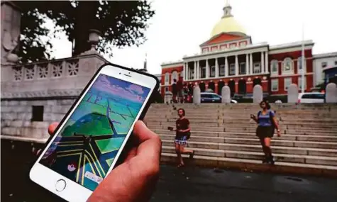  ?? AP ?? A Pokemon Go player walking through the Boston Common, outside the Massachuse­tts Statehouse in Boston. The founder of the volunteer-based historical markers website hopes people take their eyes off the game to see the historic places.