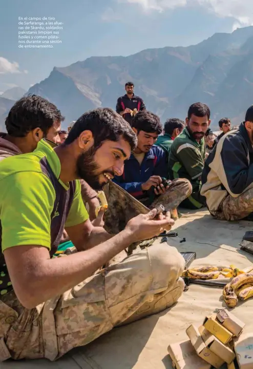  ??  ?? En el campo de tiro de Sarfaranga, a las afueras de Skardu, soldados pakistanís limpian sus fusiles y comen plátanos durante una sesión de entrenamie­nto.