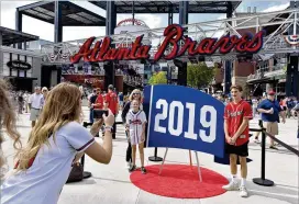  ?? HYOSUB SHIN / HYOSUB.SHIN@AJC.COM ?? Braves fans pose for a photograph at The Battery Atlanta before the start of Game 5 of the National League Division Series in October.