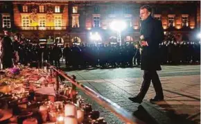  ?? AFP PIC ?? French President Emmanuel Macron at a makeshift memorial near the Christmas market in Strasbourg on Friday.