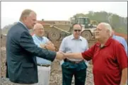  ??  ?? Engineer Pete Andersen shakes hands with hydrogreol­ogist Bruno Mercuri during the groundbrea­king ceremony for Perkasie Regional Authority’s new operations center Thursday, Oct. 4.