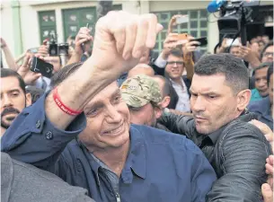  ?? AFP ?? Brazil’s right-wing presidenti­al candidate for the Social Liberal Party, Jair Bolsonaro, waves after casting his vote at Villa Militar in Rio de Janeiro.