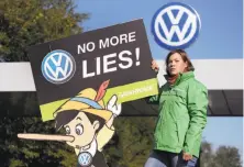  ?? Michael Sohn / Associated Press ?? A Greenpeace activist protests in front of a factory gate at Volkswagen in Wolfsburg, Germany.