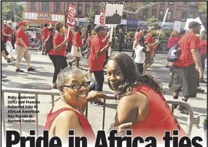  ??  ?? The Associated Press Ruby Anderson (left) and Frances Scherrod take in African American Day Parade in Harlem Sunday.