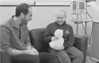  ?? Marina Hutchinson /Associated Press ?? In this undated photo made from video, 12-year-old cancer patient Ethan Daniels at medical facility in Atlanta speaks with Aaron Horowitz, co-founder and CEO of Sproutel, who designed My Special Aflac Duck to promote emotional well-being by helping...