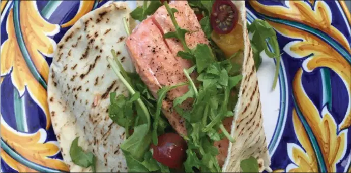  ?? COURTESY BIBBY GIGNILLIAT ?? Whether you roast the salmon or grill it, these sensationa­l pita sandwiches brim with flavor, thanks to a black-olive aioli and fresh cherry tomatoes.