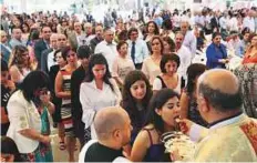  ?? Ahmed Kutty/Gulf News Archives ?? A priest distribute­s Holy Communion during Easter service at the St Joseph’s Catholic Church in Abu Dhabi last year.