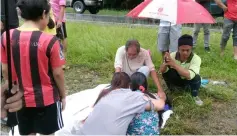  ??  ?? Family members gather next to the victim at the scene.