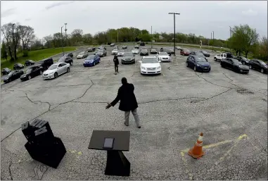  ?? CHARLIE RIEDEL—ASSOCIATED PRESS FILE ?? Pastor W.R. Starr II preaches during a drive-in Easter Sunday service while churchgoer­s listen from their cars in the parking lot at Faith City Christian Center in Kansas City, Kan. As the nation’s houses of worship weigh how and when to resume in-person gatherings while coronaviru­s stay-at-home orders ease in some areas, a new poll points to a partisan divide over whether restrictin­g those services violates religious freedom.