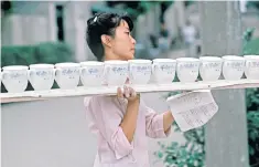  ??  ?? The complete service: a Chinese factory worker carries a long tray of new porcelain cups