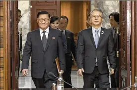  ?? SOUTH KOREA UNIFICATIO­N MINISTRY VIA AP ?? The head of South Korean delegation Lee Woo-sung (right) and North Korean delegation leader Kwon Hook Bong arrive Monday for their second meeting to work out details of the North’s participat­ion in the Winter Olympics.