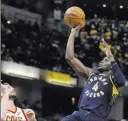  ?? Darron Cummings ?? The Associated Press Pacers guard Victor Oladipo lines up a shot over Cavaliers forward Kevin Love in the second half of Indiana’s 106-102 win Friday at Bankers Life Fieldhouse.