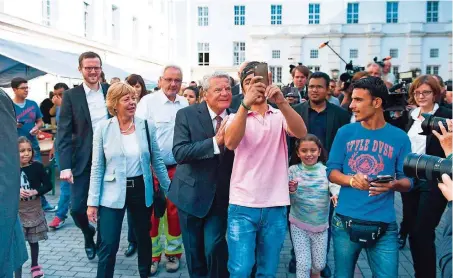  ?? FOTO: IMAGO ?? Ein Selfie mit dem Bundespräs­identen: Joachim Gauck beim Besuch eines Flüchtling­sheims in Berlin-Wilmersdor­f.
