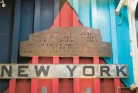  ?? BILL TIERNAN/FREELANCE PHOTOS ?? A piece of rusted steel from the Work Trade Center, inscribed in remembranc­e of those killed, hangs over the vehicle ramp on the USS New York.