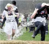  ??  ?? Dorking’s Malcolm Pernet dressed as a bride, carries ‘jockey’ Kate Barfield