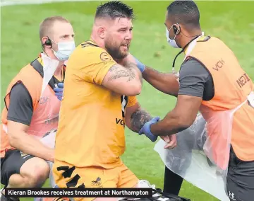  ??  ?? Kieran Brookes receives treatment at Northampto­n