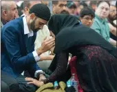  ??  ?? Raheela Hayat comforts her brother, Hamid Hayat, during prayer during Eid ul-Adha celebratio­ns.