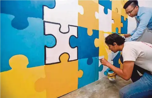  ??  ?? AHMAD Zaki memantau artis ketika menyiapkan mural.