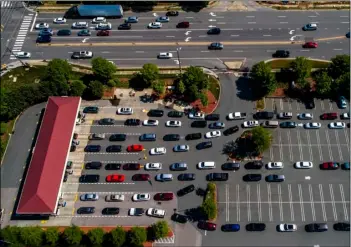  ?? The News & Observer via AP
Travis Long/ ?? Vehicles wait in lines at the Costco in Raleigh, N.C., on Thursday.