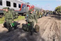  ?? ASSOCIATED PRESS ?? Russian recruits walk to take a train at a railway station in Prudboi, Volgograd region of Russia, on Sept. 29.