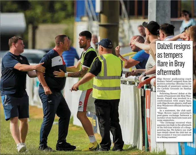  ??  ?? Sligo Rovers goalkeepin­g coach Rodney Dalzell, centre, is held back by Sligo Rovers player Patrick McClean,Tony Quinn and a match steward after a confrontat­ion with Sligo supporters after the SSE Airtricity League Premier Division match between Bray...