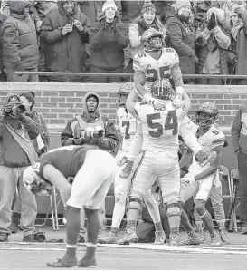  ?? Carlos Osorio / Associated Press ?? Ohio State running back Mike Weber (25) reaches new heights after scoring in the second half of the Buckeyes’ victory over Big Ten rival Michigan.