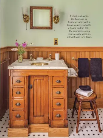  ??  ?? A black-and-white tile floor and an Eastlake vanity with a brass sink are suited to a house built in 1881. The oak wainscotin­g was salvaged when an old bank was torn down.