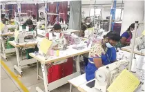  ??  ?? Workers producing garments at a manufactur­ing unit in Tirupur