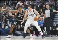 ?? Associated Press ?? Dallas Mavericks guard Luka Doncic (77) dribbles against Clippers guard Paul George (13) during the first quarter on Tuesday in Dallas. Doncic scored 35 points in the Mavericks’ 103-101 win.