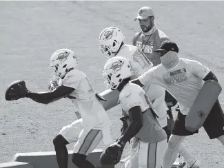  ?? CHARLES TRAINOR JR ctrainor@miamiheral­d.com ?? Dolphins’ Chester Rogers, front, caught a pass from rookie Tua Tagovailoa in Tuesday’s practice, but fumbled it.