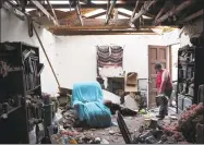  ?? Joe Raedle / Getty Images ?? Amanda Logsdon begins the process of trying to clean up her home after the roof was blown off by the passing winds of hurricane Michael on Thursday in Panama City, Fla. The hurricane hit the Florida Panhandle as a category 4 storm.