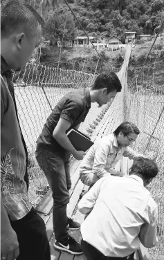  ??  ?? Dennis (second right) and JKR Miri staff inspecting the main structure of the bridge.