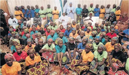  ?? /BAYO OMOBORIOWO/ REUTERS ?? Nigeria's President Muhammadu Buhari applauds as he welcomes a group of Chibok girls, who were held captive for three years by Boko Haram, in Abuja, Nigeria on Sunday.
