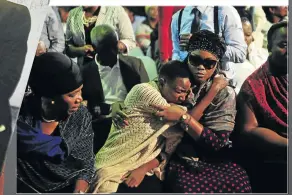  ??  ?? Mourners struggle to hold back tears during Lundi’s memorial service.